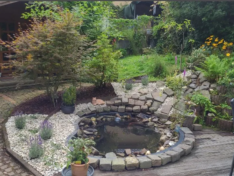 Bepflanzter Garten mit Teich, Steinen und Beeten